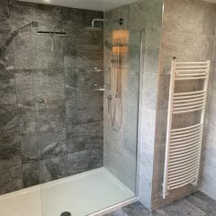 Grey bathroom refurbishment with rain shower - Thomson Properties, bathroom refurbishment specialists Surrey and Sussex