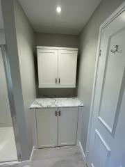 White bathroom units within bathroom refurbishment by Thomson Properties, Surrey & Sussex