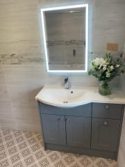 Complete bathroom refurbishment with patterned floor tiles and illuminated mirror by Thomson Properties