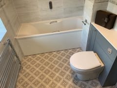 Bathroom refurbishment with patterned floor tiles and grey furniture - Thomson Properties