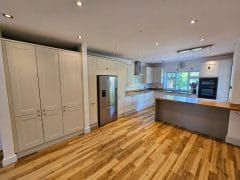 White shaker style kitchen with wooden flooring and underfloor heating by Thomson Properties